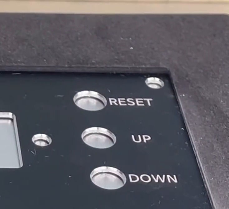 설비 조작 패널에 레이저로 각인된 RESET·UP·DOWN 표기 — 글자가 판 표면에 직접 새겨져 있다